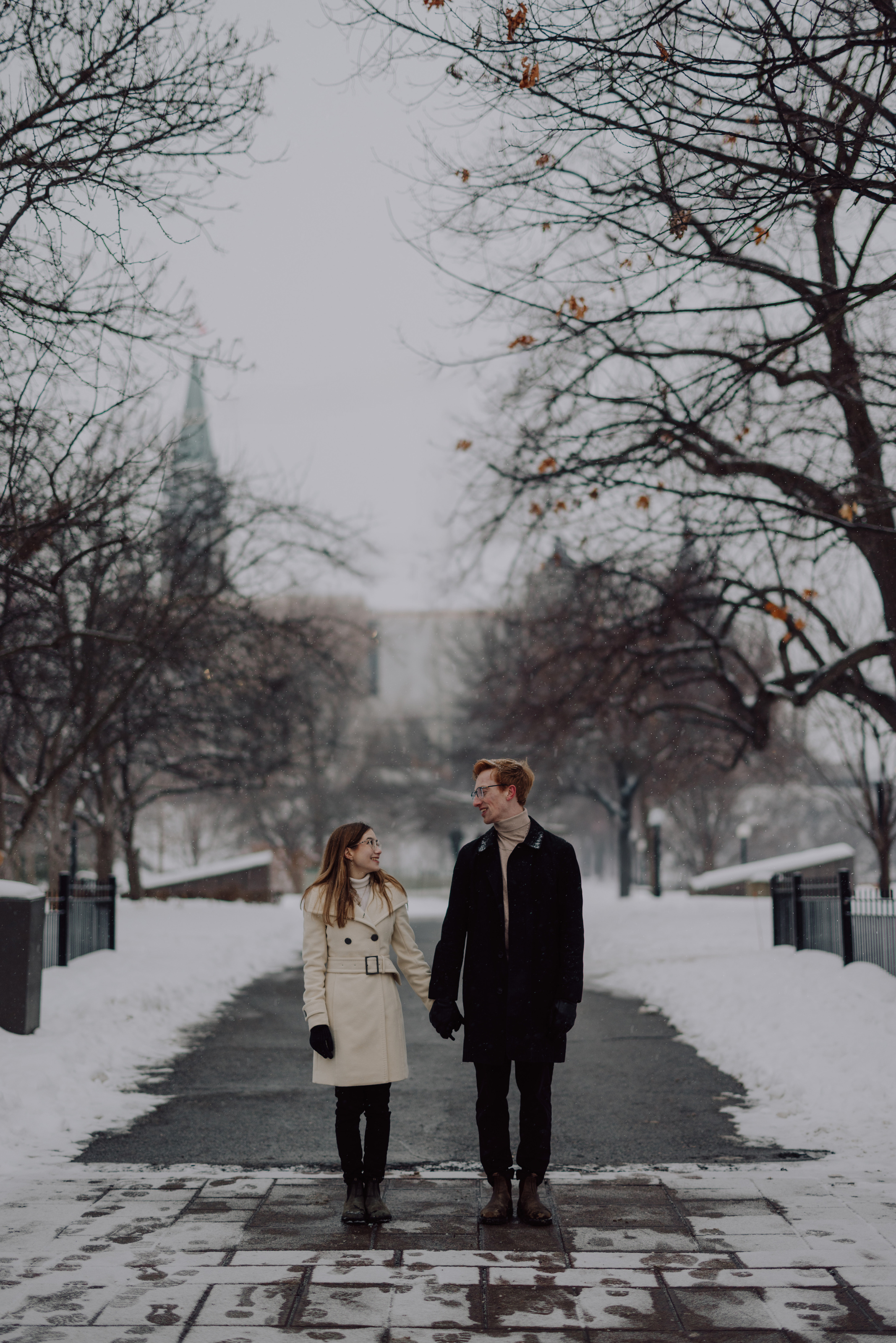 Kaitlyn and Alex holding hands on a snowy path in downtown Ottawa